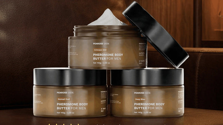 Three Penrose Skin pheromone body butter jars stacked on leather in warm light